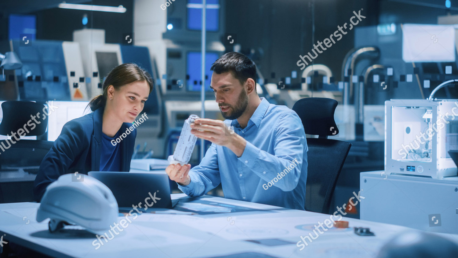 stock-photo-industry-modern-factory-meeting-room-chief-engineer-holds-mechanism-shows-it-to-female-1936499791